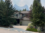 house nestled in trees and mountains