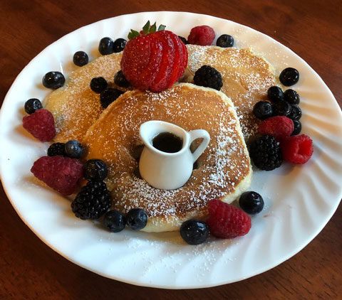 pancakes with strawberries and maple syrup